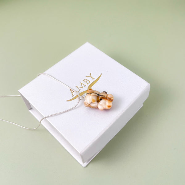 Pakabukas su gintariniu meskuciu.